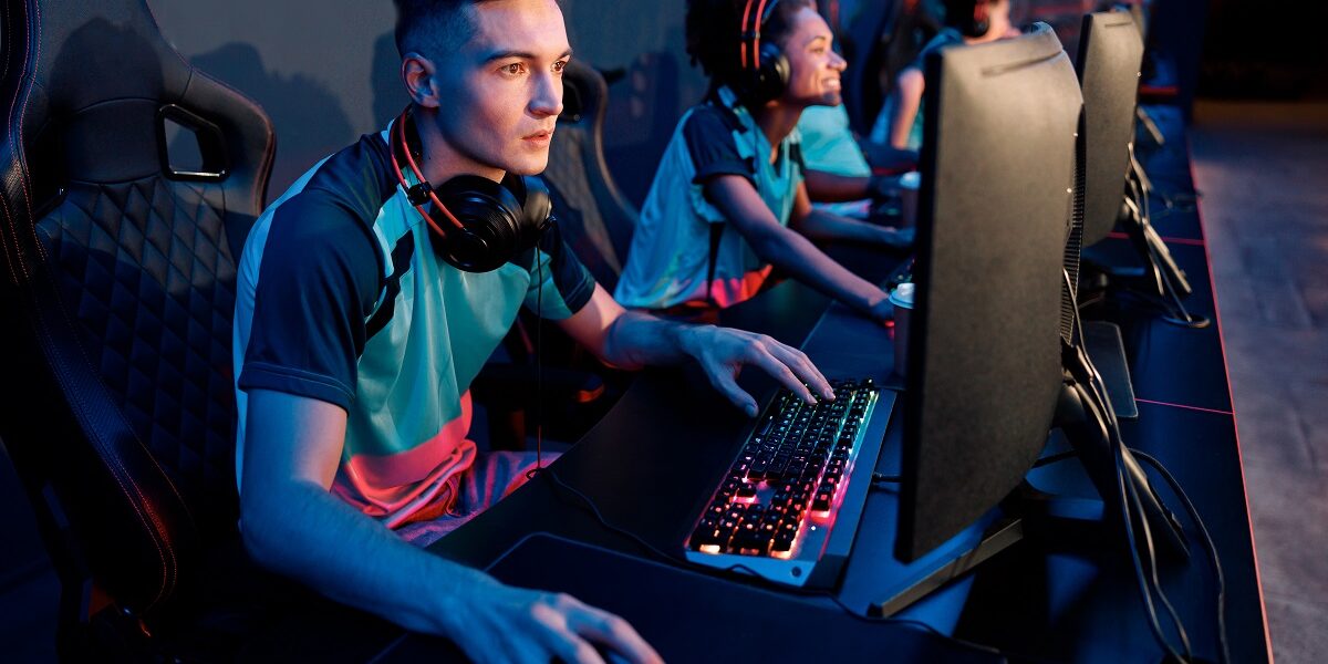 Esports team playing game on computers in gaming club